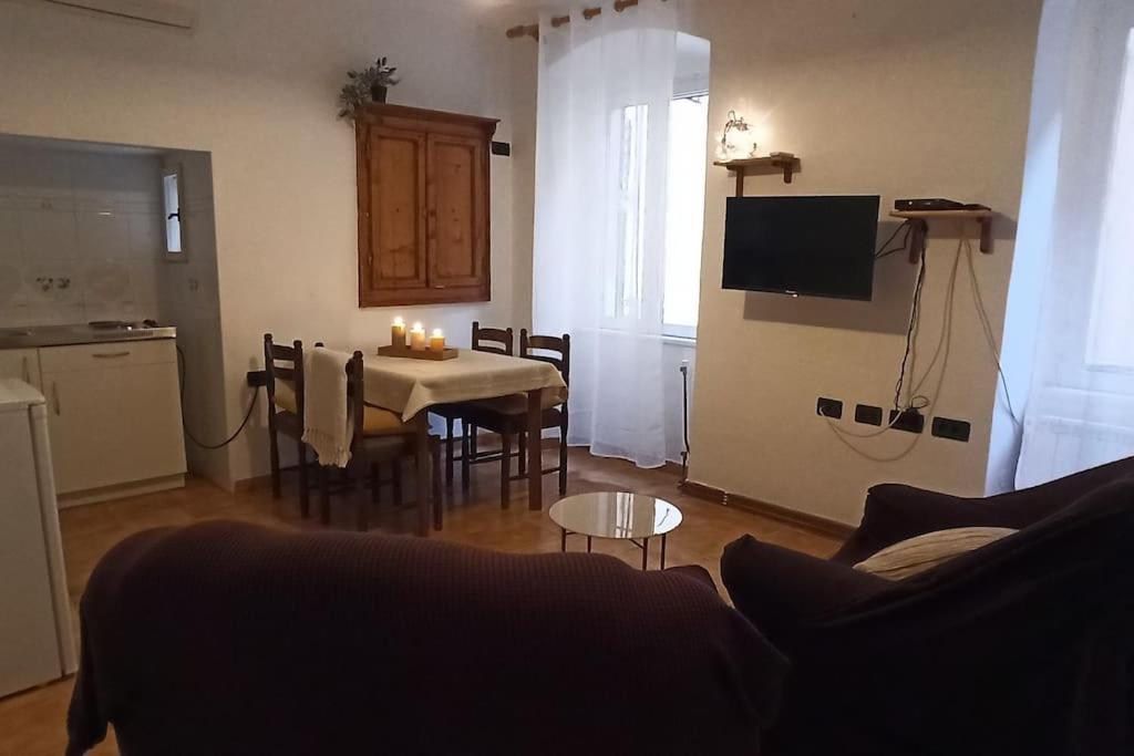 ein Wohnzimmer mit einem Tisch und eine Küche mit einem TV in der Unterkunft ELLE in Rovinj