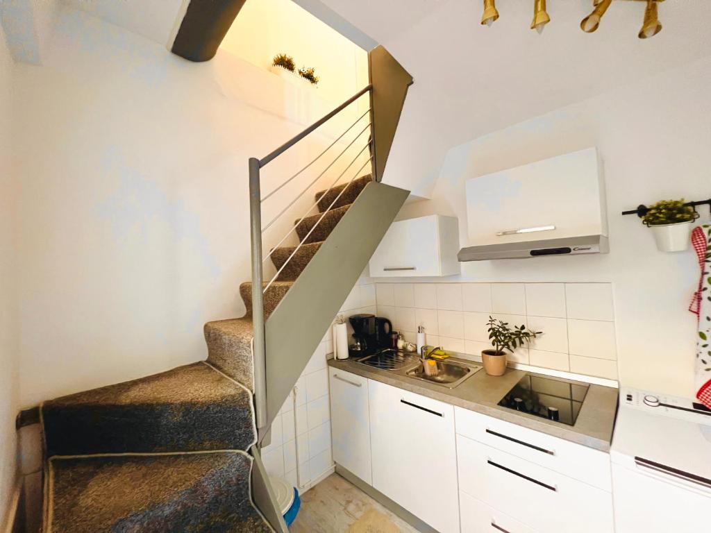 a kitchen with a staircase in a small room at Little Sunflower in Matulji