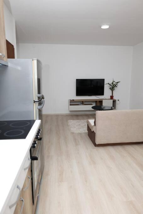 a white living room with a stove and a couch at Gramosli Apartment in Bitola