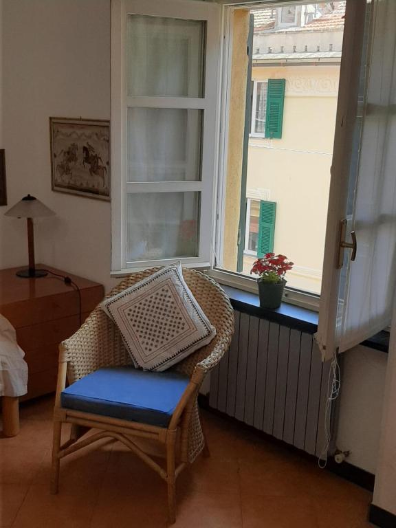 a wicker chair sitting in a room with a window at Casa Francesca, vicino al mare in Sestri Levante