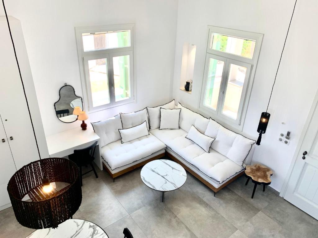a living room with a white couch and two windows at Syboro in Aloïziánika