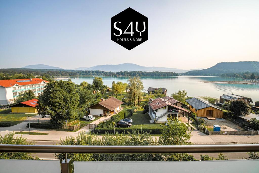 vistas a una ciudad con un lago y casas en Hotel Faaker See Inn by S4Y, en Faak am See