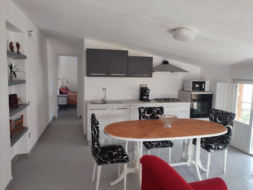 een keuken met een tafel en stoelen in een kamer bij La manSarda in Tortolì