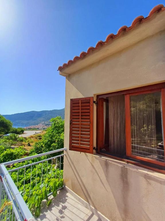 a balcony of a house with a window at Apartman Mihaela in Komiža