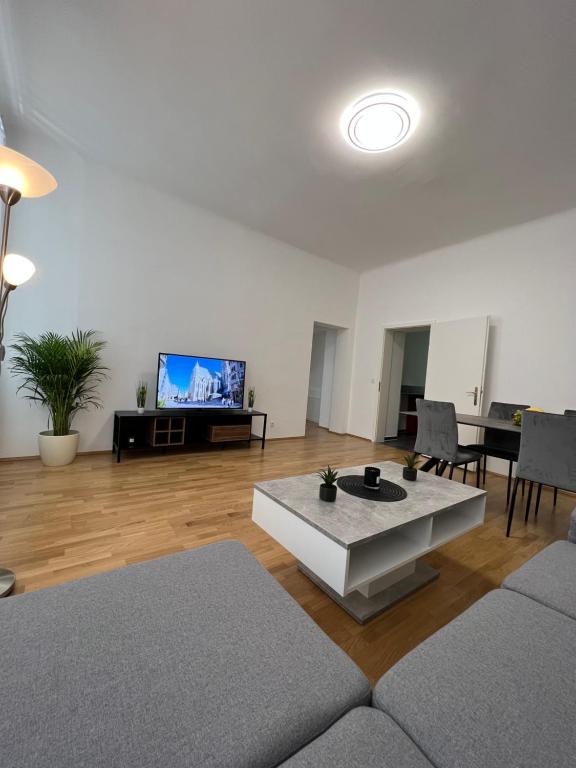 a living room with a couch and a table and a tv at Modernes Juwel in zentraler Lage in Vienna