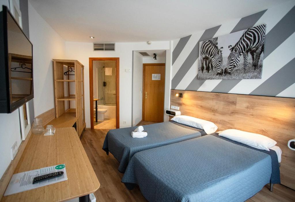 リョレート・デ・マルにあるHotel Ridomar 365のベッドルーム1室(ベッド2台付)、壁にシマウマ2本