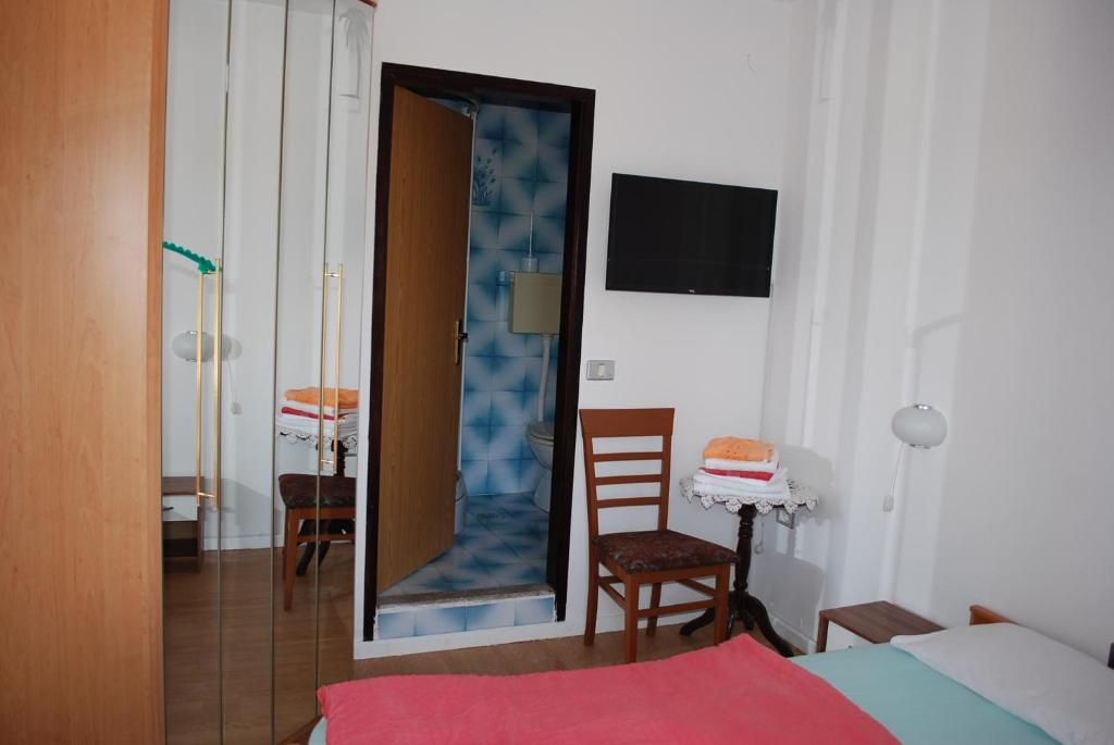 ein Schlafzimmer mit einem Spiegel, einem Bett und einem Tisch in der Unterkunft Penzion Palma in Sečovlje