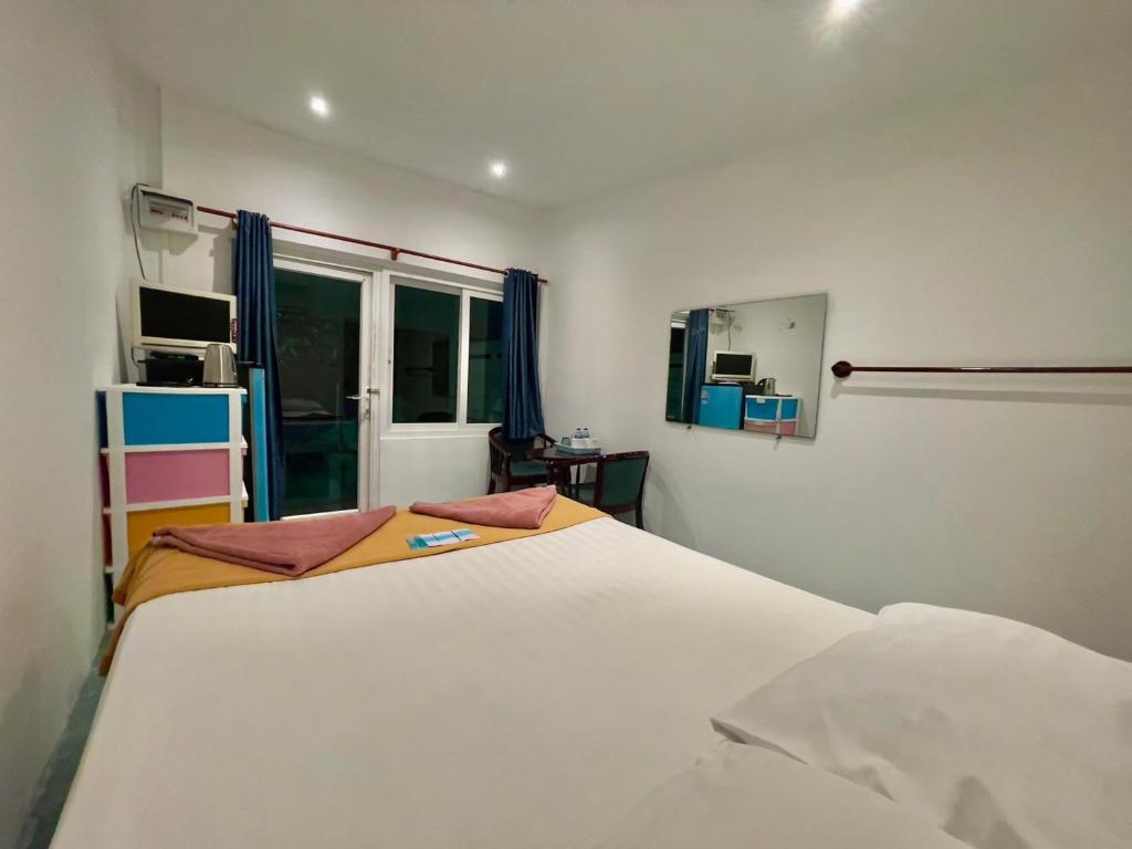 a bedroom with a large white bed and a window at Naiharn On The Rock Resort Phuket in Nai Harn Beach