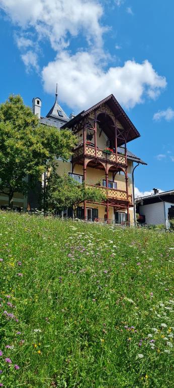 una grande casa in cima a una collina erbosa di Villa Franz Xaver a St. Wolfgang