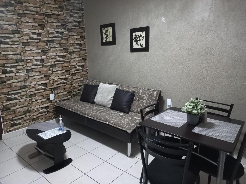 een woonkamer met een bank en een tafel bij Cómodo & confortable apartamento. 5 minutos del aeropuerto in Mexico-Stad