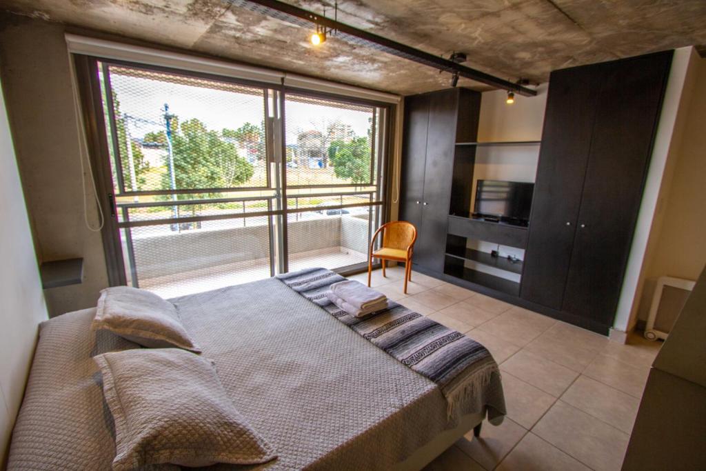 a bedroom with a bed and a large window at Espectacular Loft a estrenar !! in Godoy Cruz