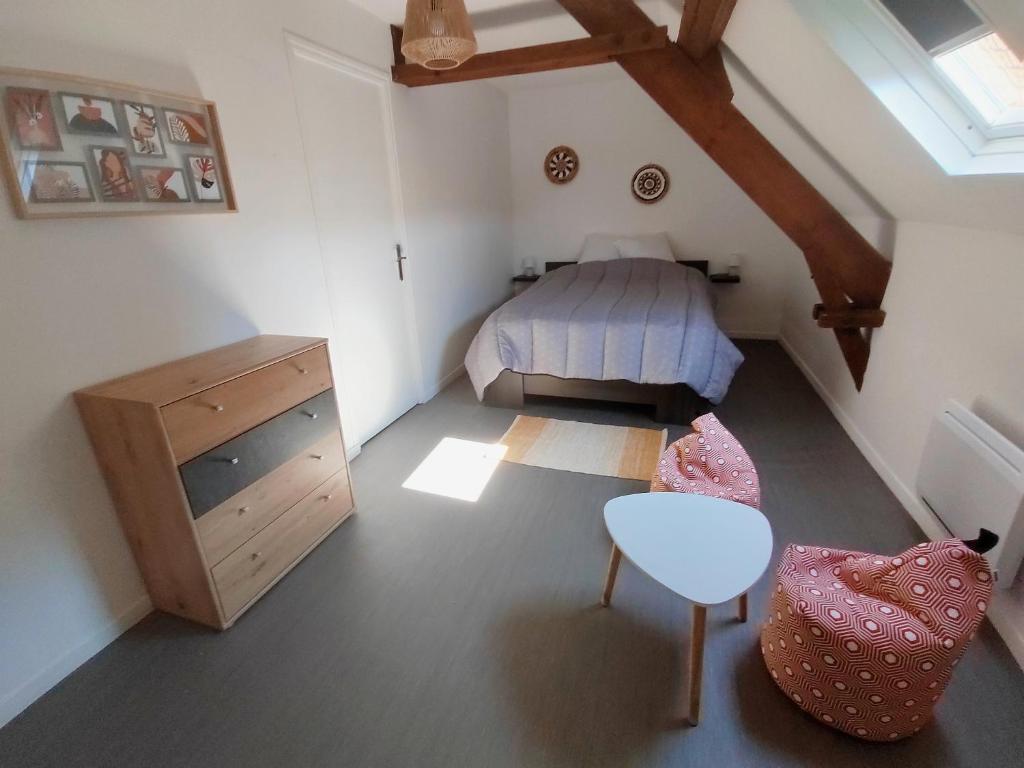 a bedroom with a bed and a desk and a table at La Maison de la Plage in Arromanches-les-Bains
