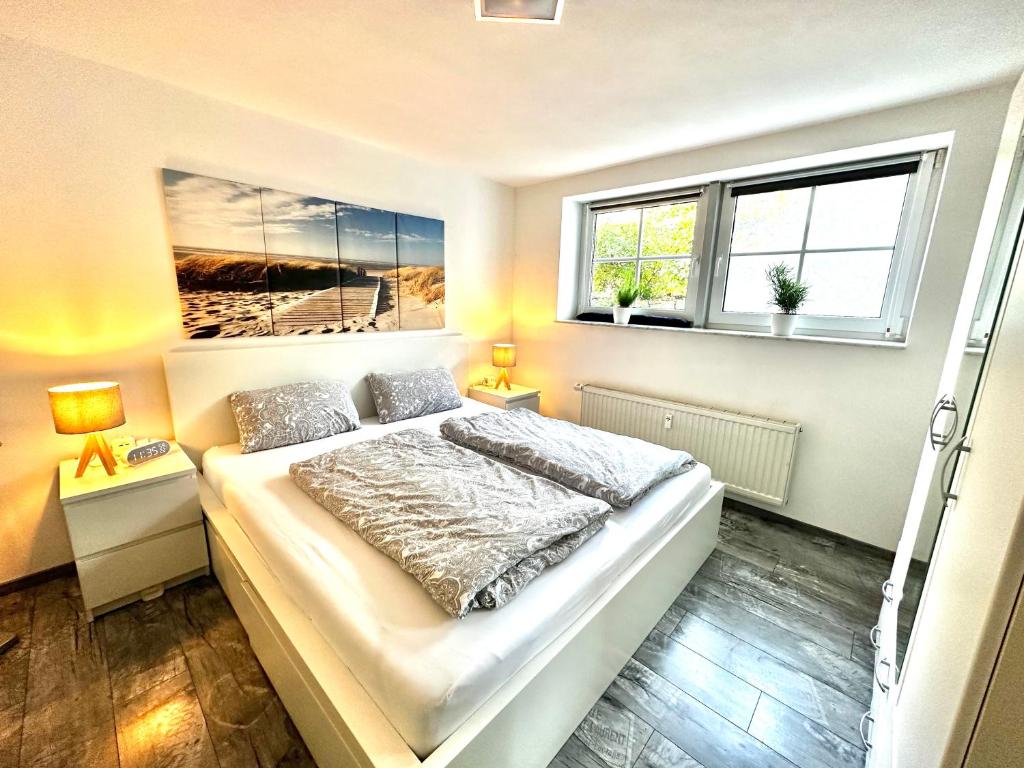 a bedroom with a bed and two windows at Modernes Apartment mit Terrasse und Highspeed Internet zwischen Aalen und Schwäbisch Gmünd in Göggingen