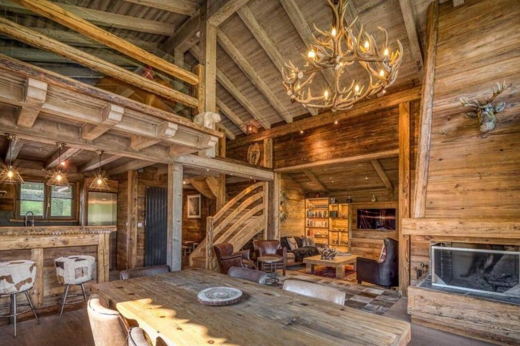 a dining room with a wooden table and a chandelier at Chalet Canopée in Demi-Quartier