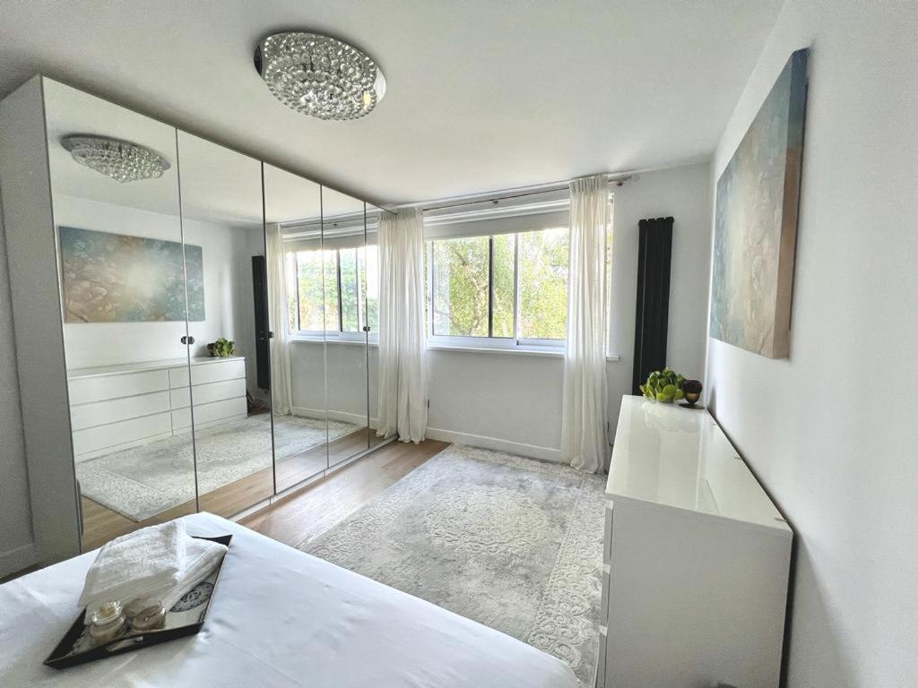 a white room with a shower and a large mirror at Modern Luxury Flat in Putney in London