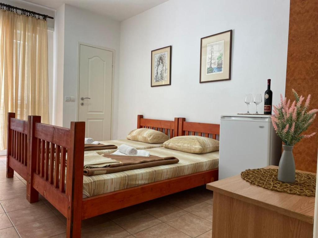 een slaapkamer met 2 bedden en een koelkast bij Jelić apartmani in Sutomore