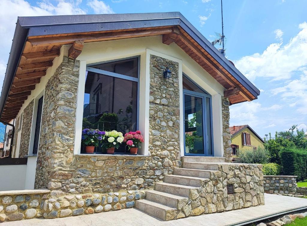 een klein stenen huis met bloemen in een raam bij Olia House in Olginate