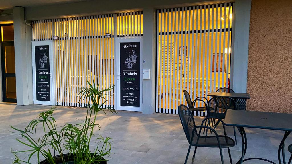 a table and chairs sitting in front of a building at Umbria Green Central Rooms in Castiglione del Lago