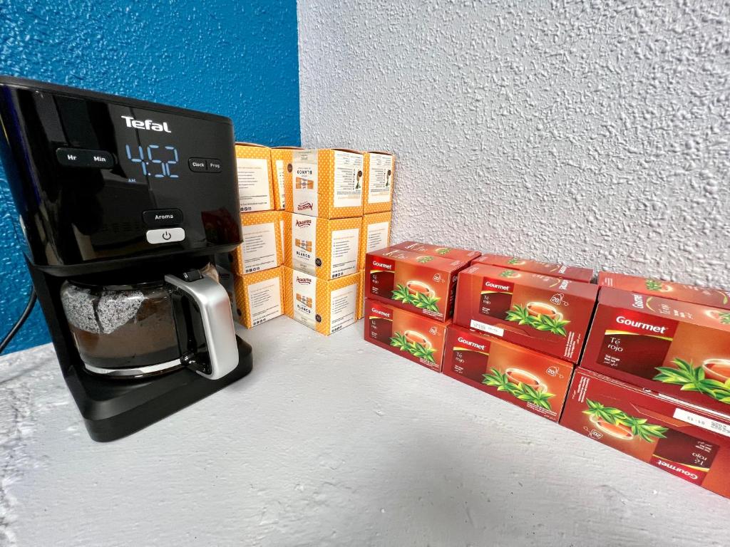 una cafetera está sentada junto a cajas de comida en Hostel Acacias, en Madrid