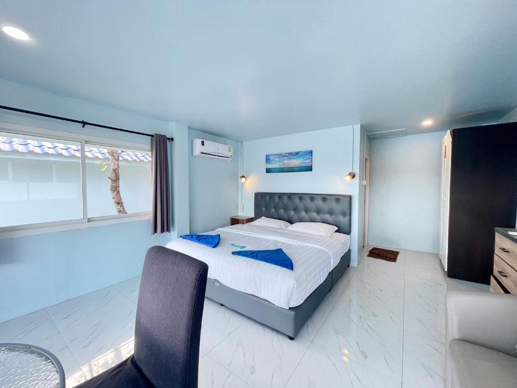 a bedroom with a large bed and a window at Naiharn On The Rock Resort Phuket in Nai Harn Beach
