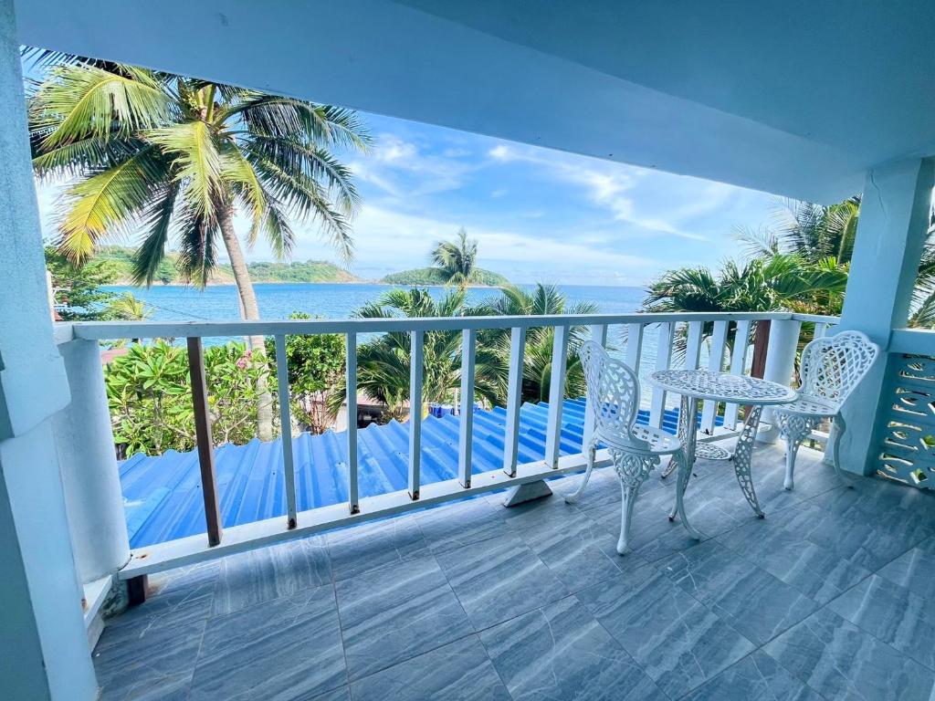 a balcony with a table and chairs and a view of the ocean at Naiharn On The Rock Resort Phuket in Nai Harn Beach