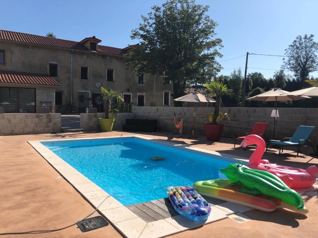 - une piscine avec un jouet aux nouilles en face d'une maison dans l'établissement Le Moulin du Chardonnet, à Tramolé