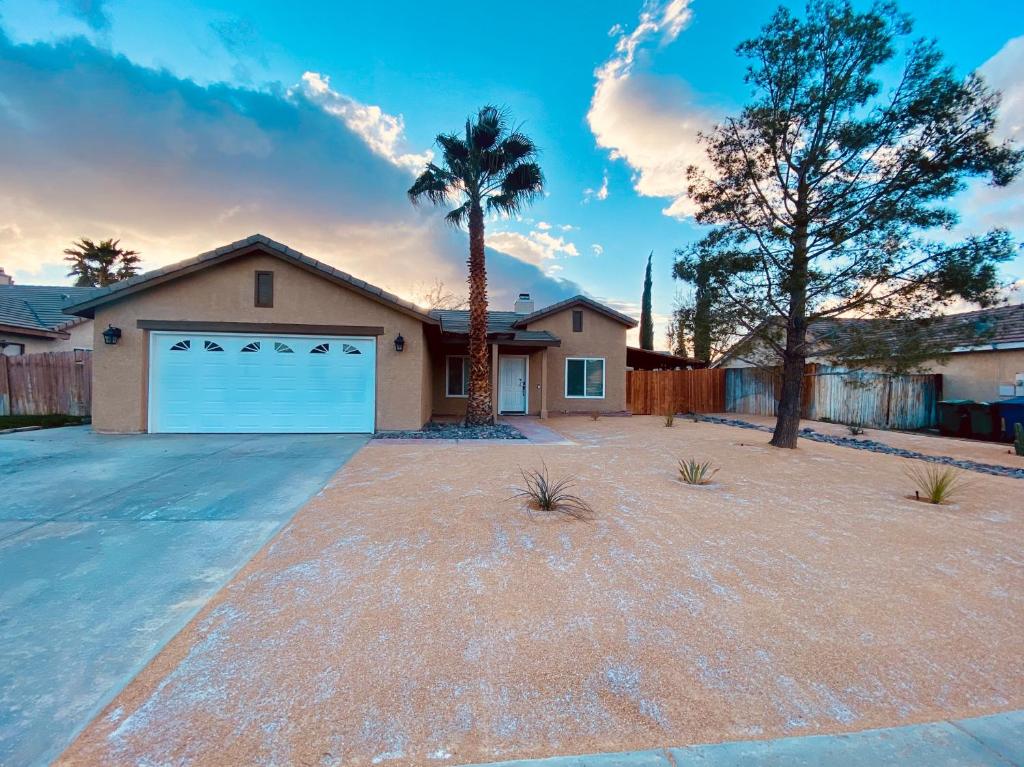 a house with a garage and a palm tree at Beautiful single story 4 br. home in nice area. in Palmdale