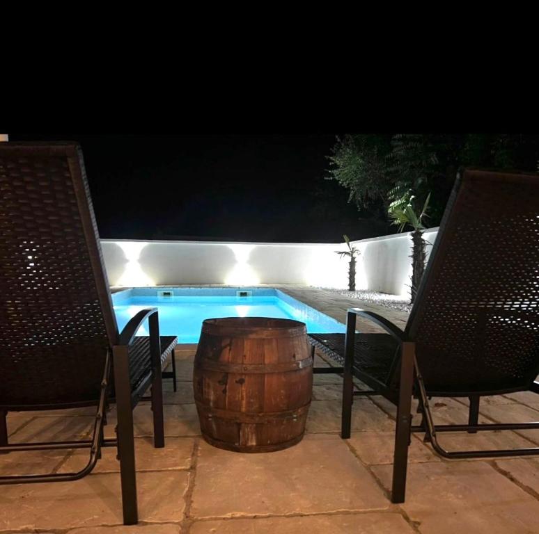 a barrel sitting next to two chairs and a swimming pool at Radovanovic in Matulji