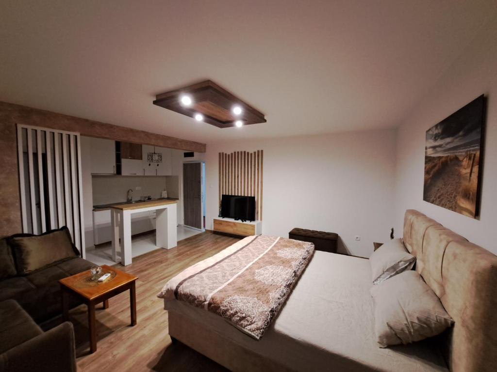 a living room with a bed and a couch at In apartmani in Nikšić