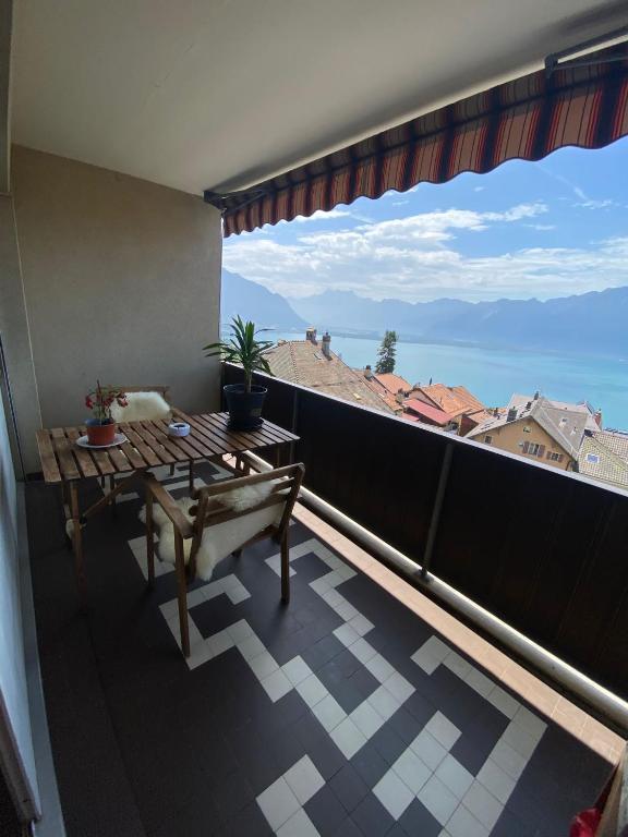 einen Balkon mit einem Tisch und Stadtblick in der Unterkunft Studio vue Lac in Montreux