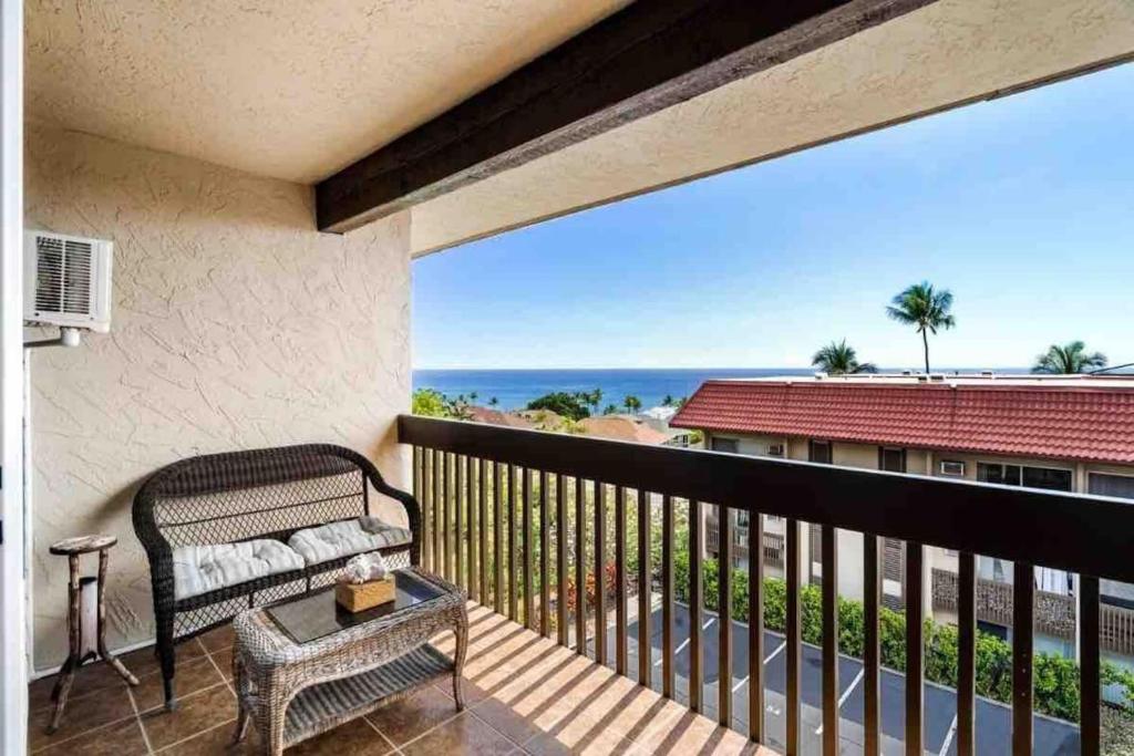 a balcony with a bench and a view of the ocean at Escape to Paradise King Bed AC Kailua Bay Sunset View Walk to Town in Kailua-Kona