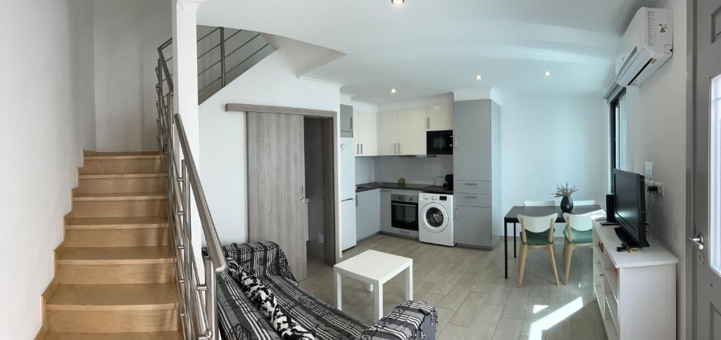 uma sala de estar com uma escada e uma cozinha em CASA LOPES em Olhão