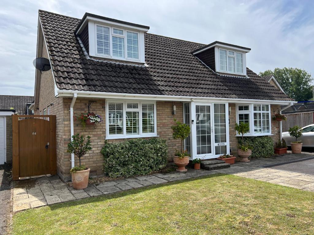 a brick house with white windows and potted plants at No 64 Bed and Breakfast in Lymington