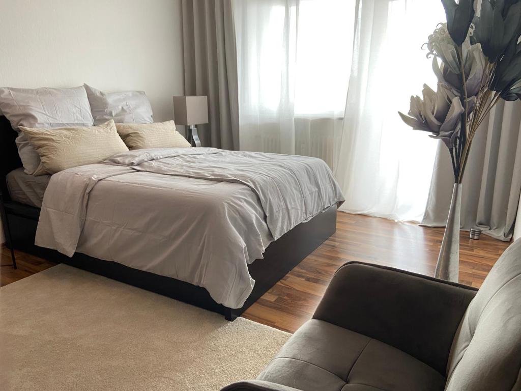 - une chambre avec un lit, une chaise et un canapé dans l'établissement CHALET_3 Design Appartments, à Waldbüttelbrunn