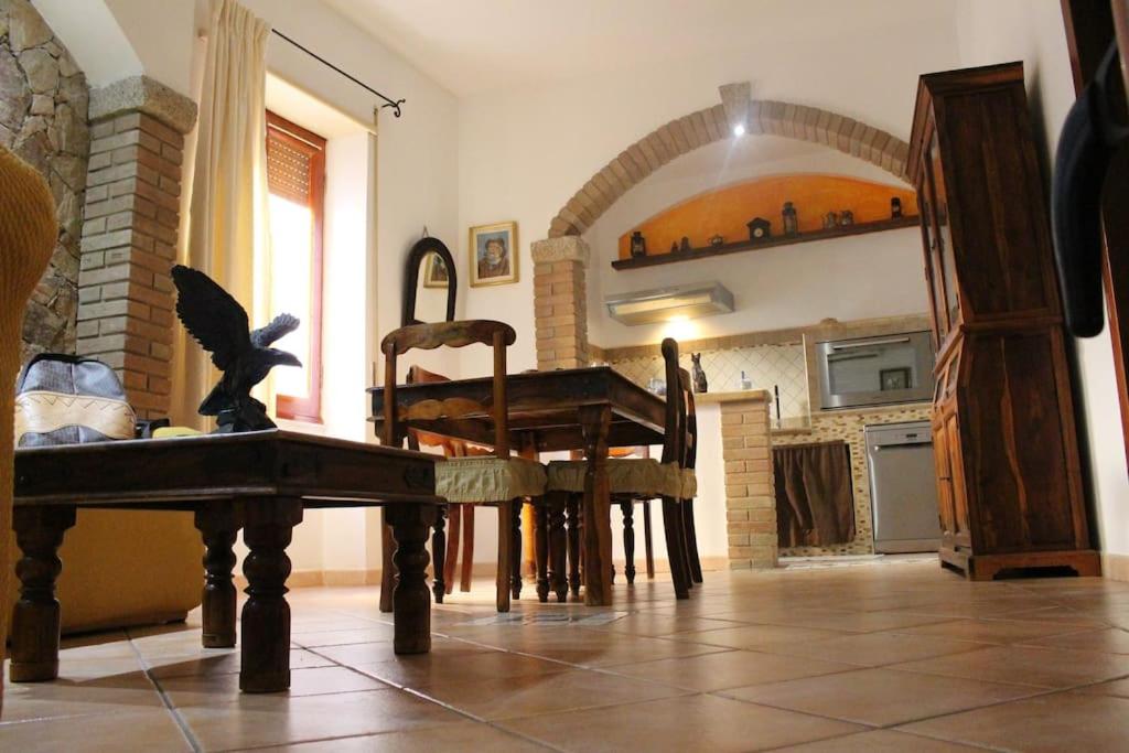 una cucina con tavolo e sedie in una stanza di La Dimora nel Borgo a Tempio Pausania