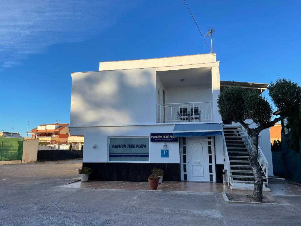 a white building with a staircase in front of it at Tere Playa in Burriana