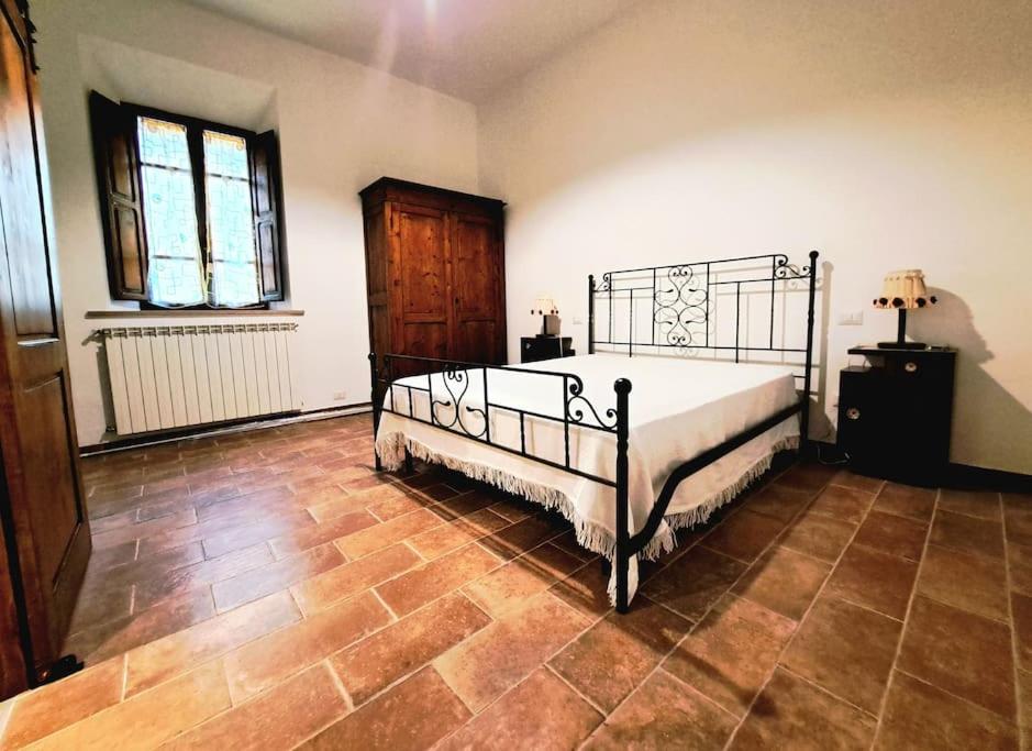 a bedroom with a bed and a wooden floor at Nel centro storico di Trequanda in Trequanda