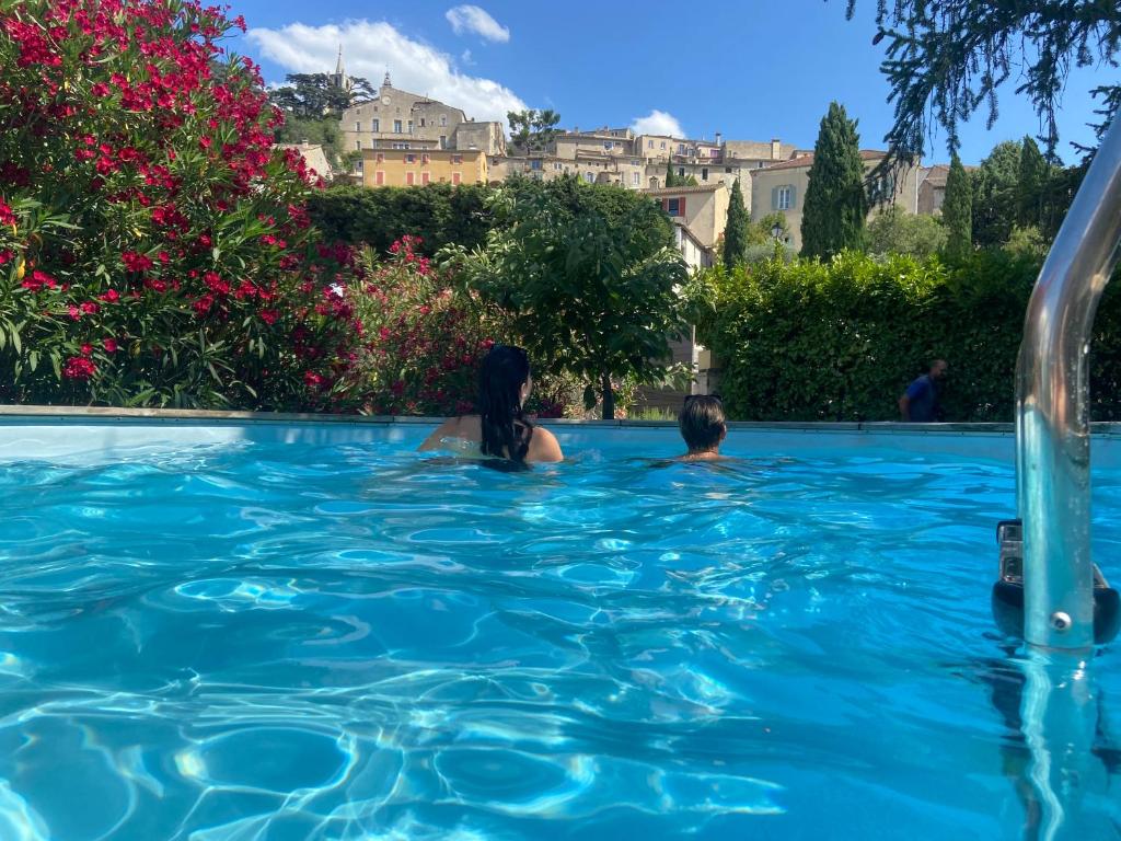 two people swimming in a swimming pool at La roseraie Bonnieux in Bonnieux