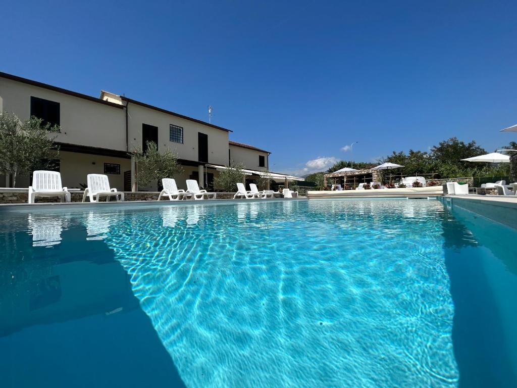 una gran piscina con sillas blancas y un edificio en Il Canneto en Sestri Levante