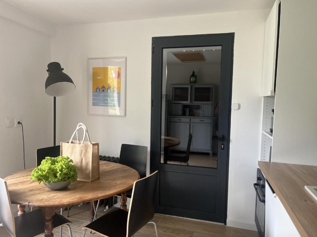 une salle à manger avec une table et une porte noire dans l'établissement Gîte à 3 minutes à pied de la mer, à Bernières-sur-Mer