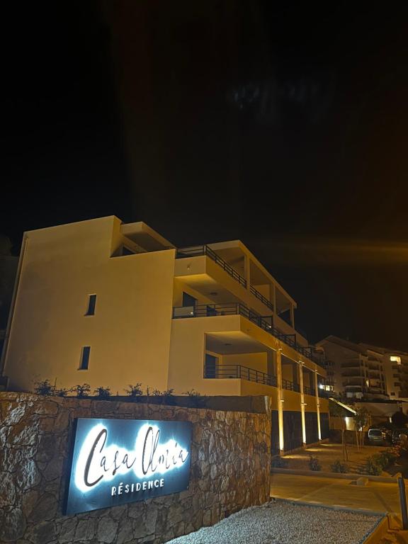 een gebouw waar 's nachts een bord voor staat bij Casa Olmia Résidence in Calvi