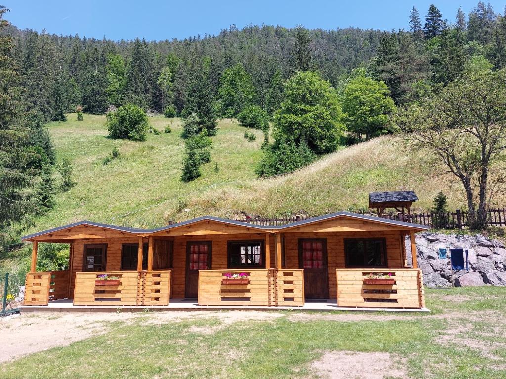 a log cabin with a hill in the background at Autokemp / Speleocamp Malužiná in Malužiná