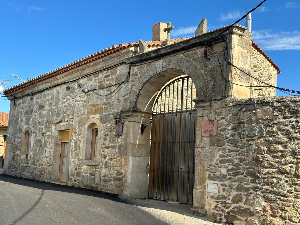 un antiguo edificio de piedra con una gran puerta de madera en La Casona Medieval, en Malillos