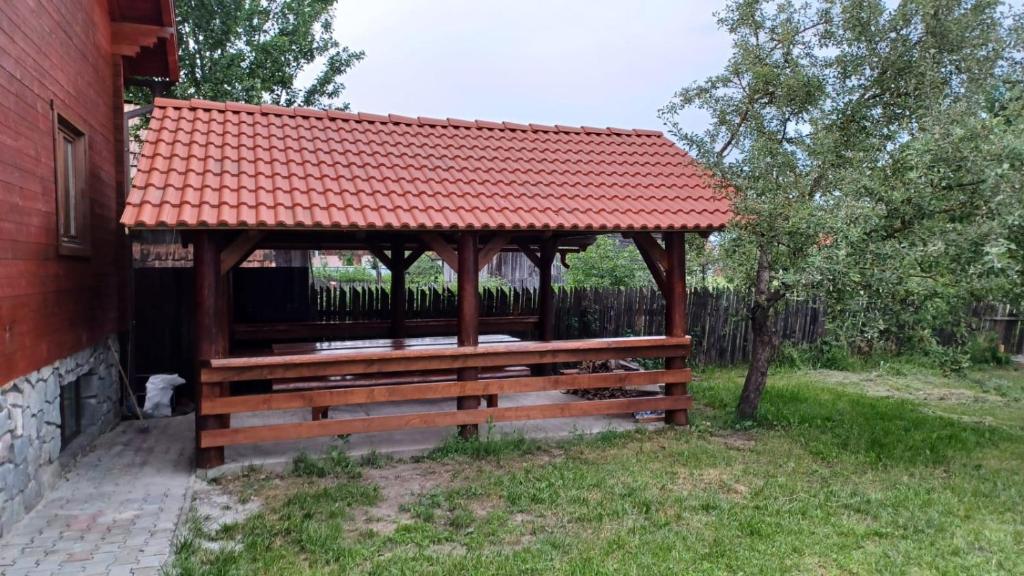 a wooden gazebo with a red roof at Lipovan kulcsosház in Ciba
