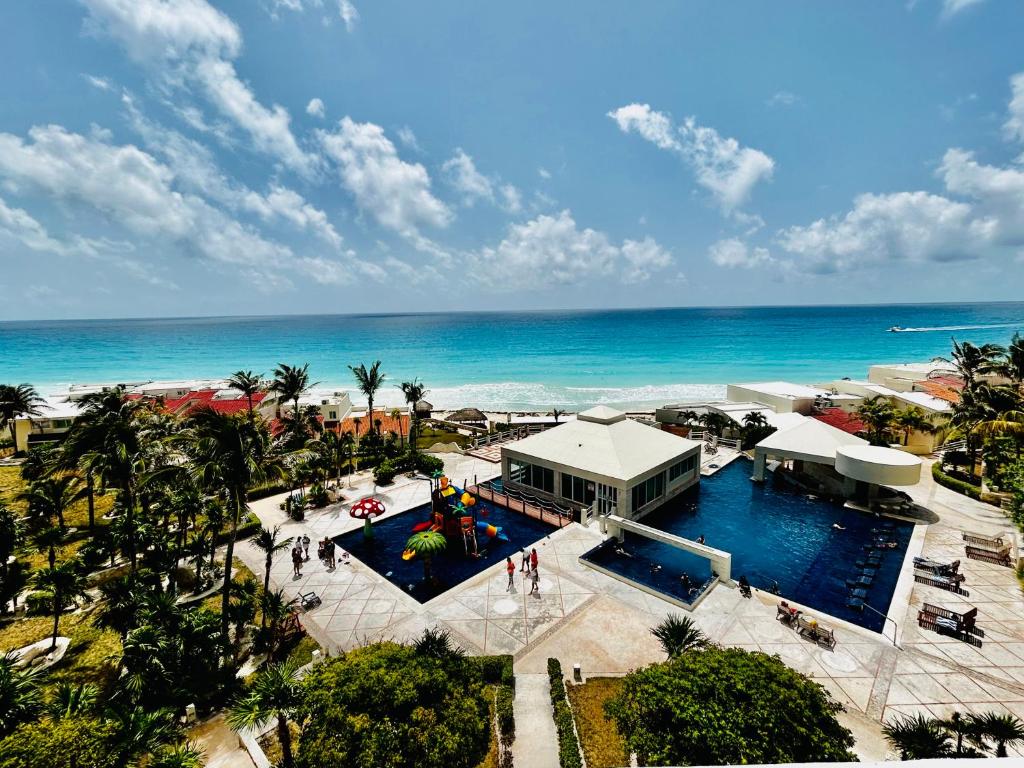 an aerial view of a resort with a pool and the ocean at The Suites of Solymar in Cancún