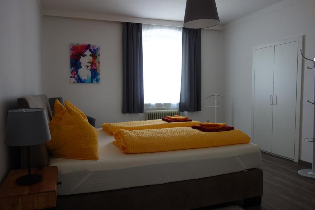 Stiftsblick في شبيتال أم بيرن: غرفة نوم بسرير مع شراشف صفراء ونافذة