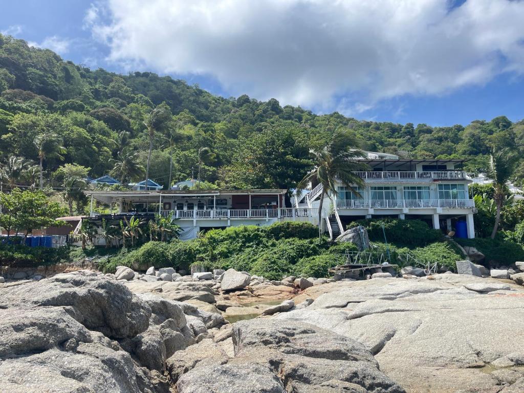 a large house on a hill with rocks at Naiharn On The Rock Resort Phuket in Nai Harn Beach