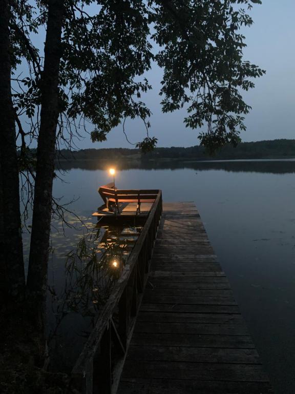 a dock on a lake with a candle on it at Poilsis ant Virintų ežero kranto in Molėtai