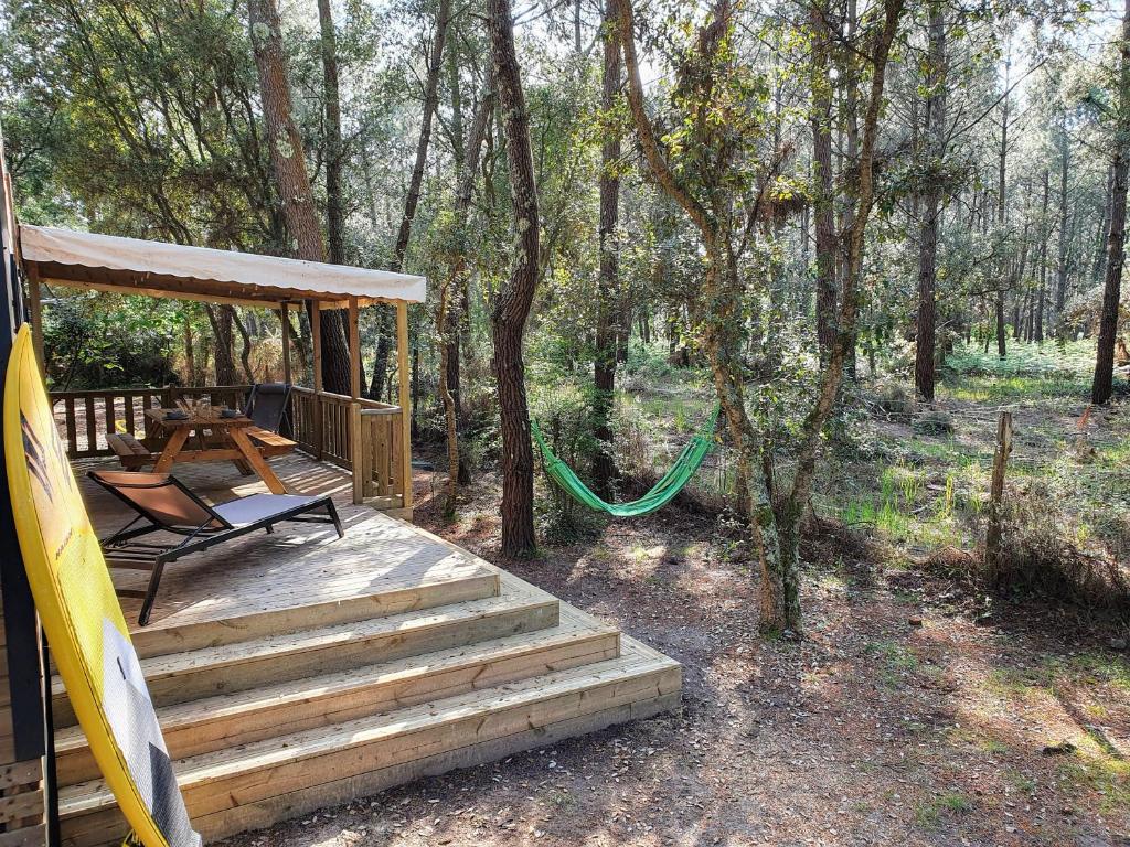 a porch with a swing and a hammock on a deck at Espace Blue Océan in Ondres