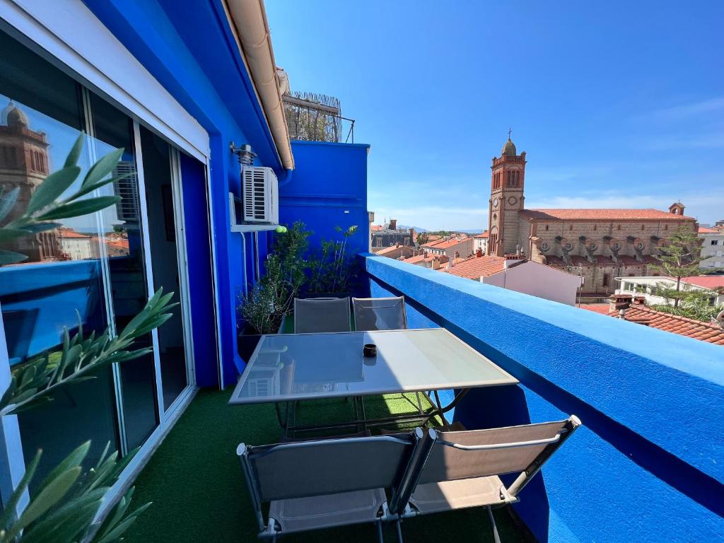 une table et des chaises sur le balcon d'un bâtiment dans l'établissement Roussillon appart avec terrasse, à Perpignan